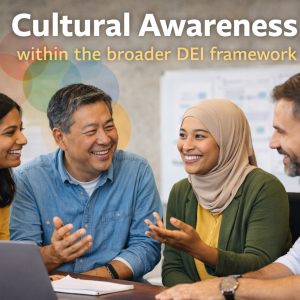 Four colleagues sit at a table, smiling and talking beneath a sign reading "Cultural Awareness in DEI.
