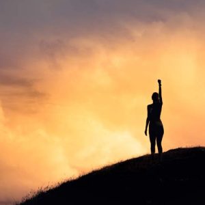 Person’s silhouette on a hill at sunset; text: Building Confidence and Assertiveness - Self Study.