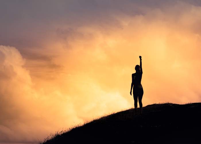 Person’s silhouette on a hill at sunset; text: Building Confidence and Assertiveness - Self Study.