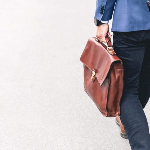 Person in blue blazer and dark pants holding “Business Ethics - Self Study” product.
