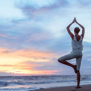 Person doing yoga at sunset with “Health and Wellness at Work - Self Study” highlighted nearby.