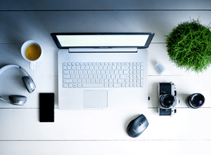 Microsoft Excel 2024 - Self Study book on desk with coffee, camera, lens, mouse, phone, and plant.