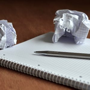 Microsoft OneNote 2024 Self Study guide on desk next to crumpled graph paper sheets.